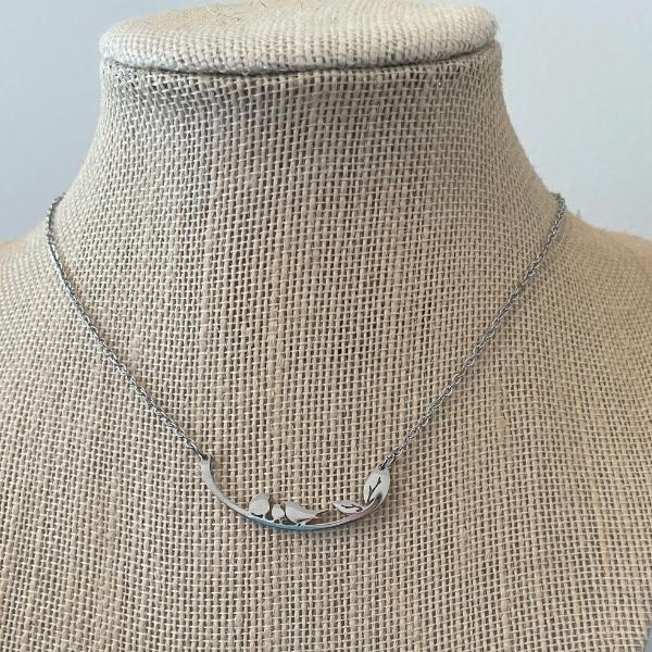 three little birds necklace on a jewelry stand
