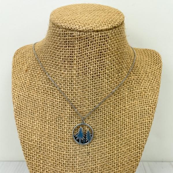 silver toned pine tree necklace on a necklace stand