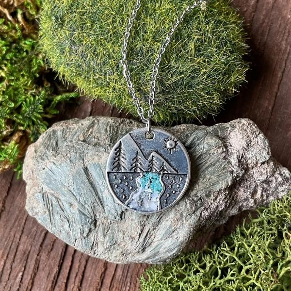 pine tree necklace with crystals displayed on a rock