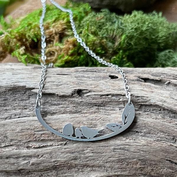 three little birds necklace on a piece of woods